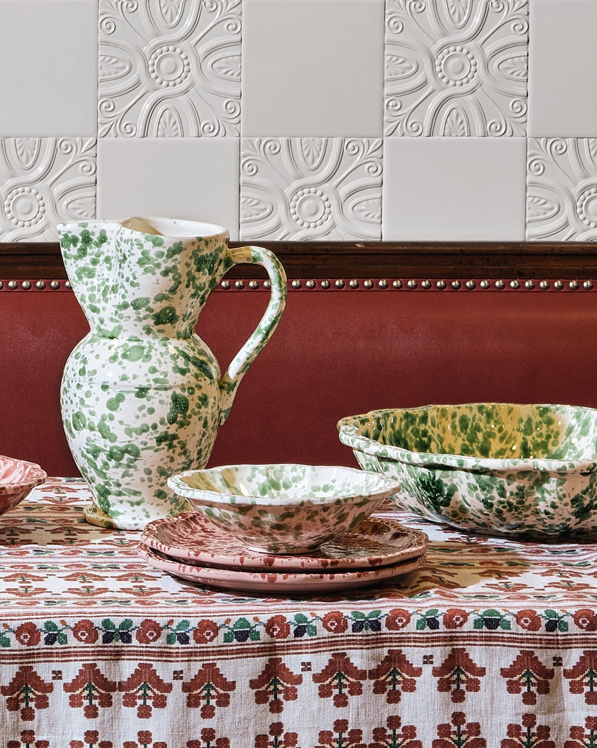 Angled view of Speckled Small Bowl in Green and White showcasing its green speckled ceramic finish with patterned table setting