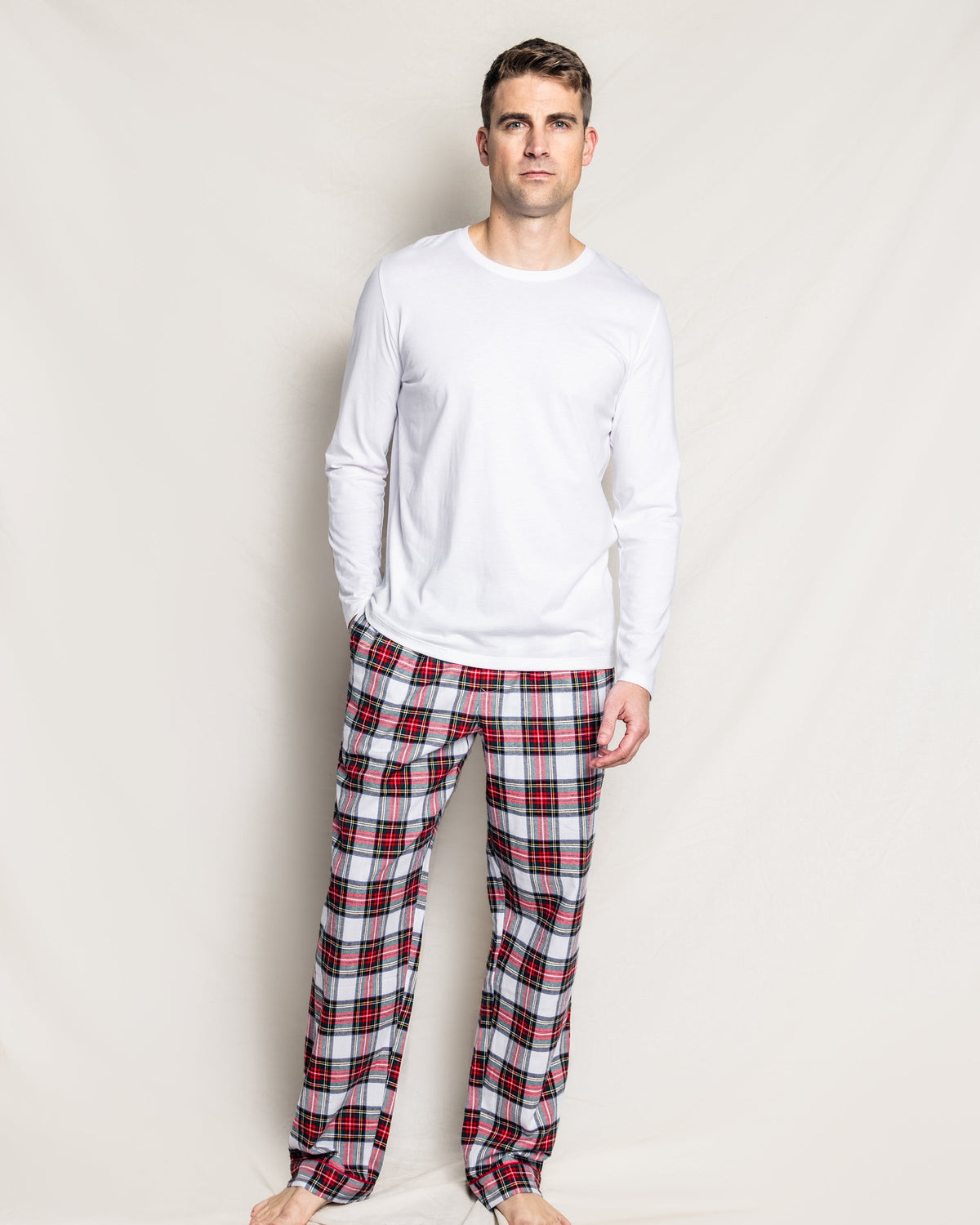 Front view of Men’s Balmoral Tartan Pants showcasing red piping and plaid pattern on a model against a white background