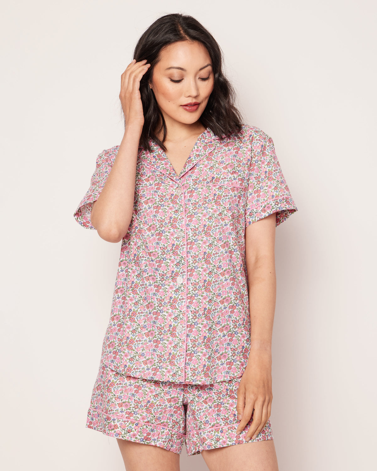 Front view of Women’s Fleurs de Rose Short Sleeve Short Set showcasing pink floral print, pink piping, and pearl buttons on a model