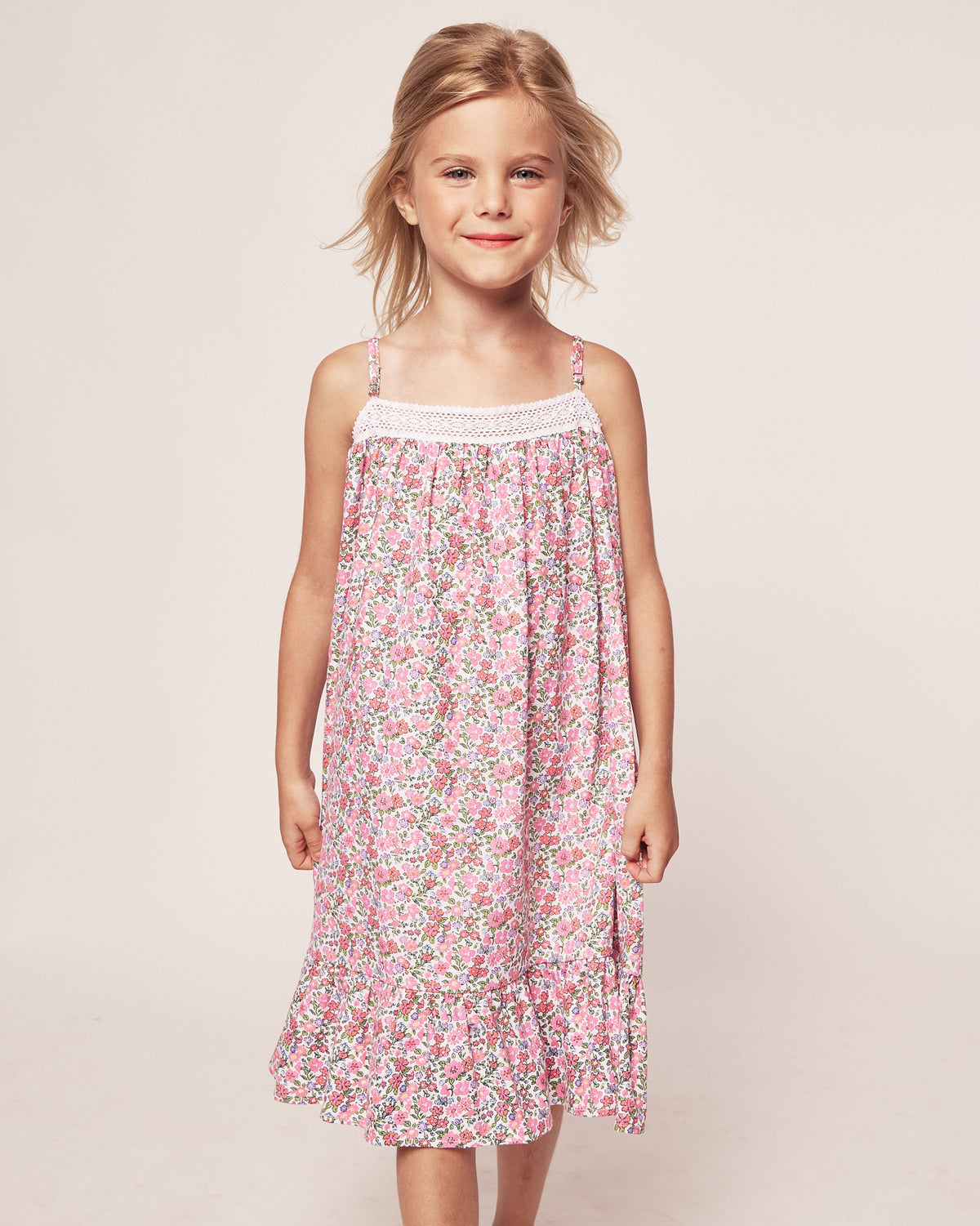 Front view of Children’s Fleurs de Rose Lily Nightgown with pink floral print and lace neckline on a child model