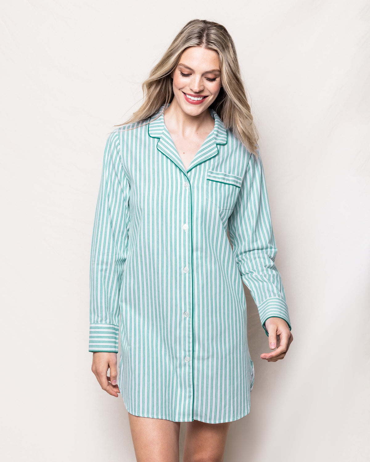 Front view of emerald striped nightshirt on model showing button front, chest pocket, long sleeves against light background