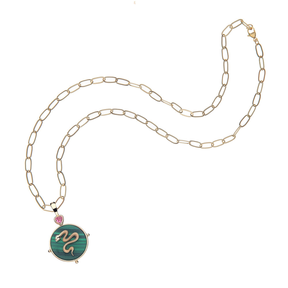 Flat lay of Protect Malachite pendant necklace showing round malachite disk, gold snake and pink heart on white background