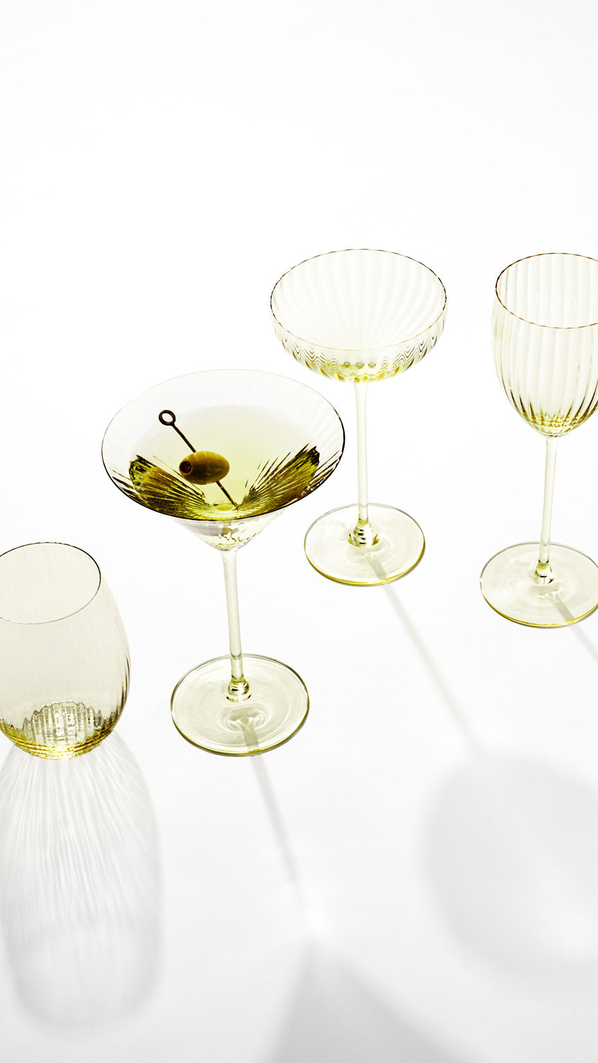 Overhead view of Quinn Citrine martini glass showcasing fluted bowl texture and pale citrine tint with olive garnish on white background