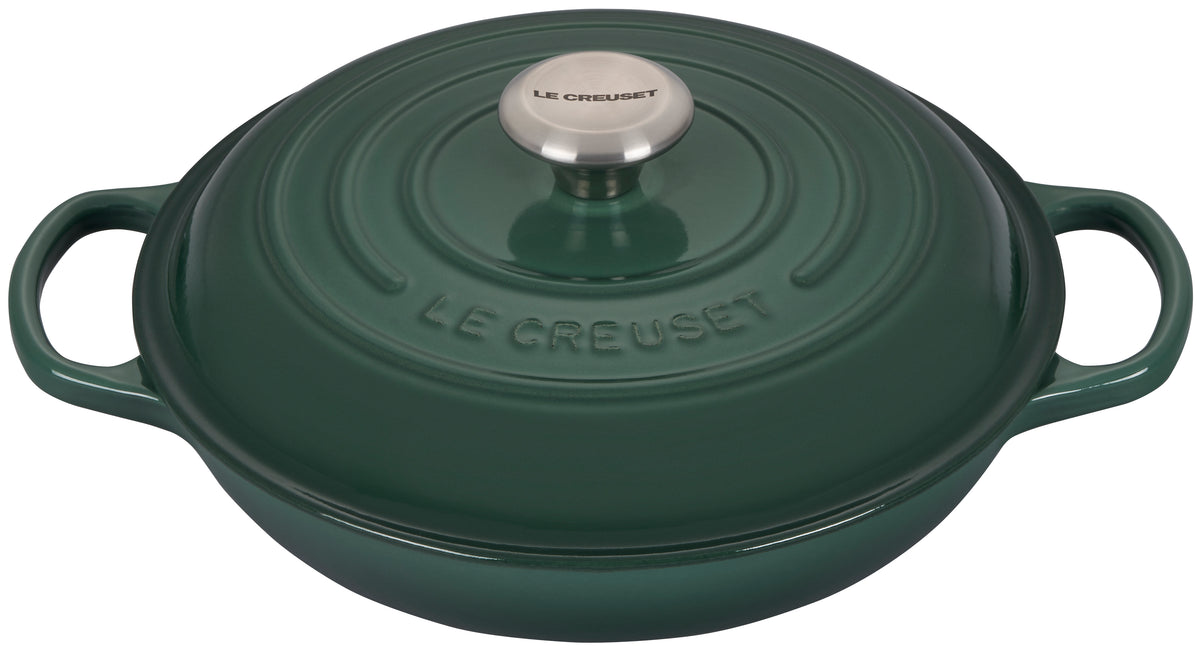 Top view of Le Creuset Signature Braiser in artichaut green with domed lid, stainless steel knob, and loop handles on white background