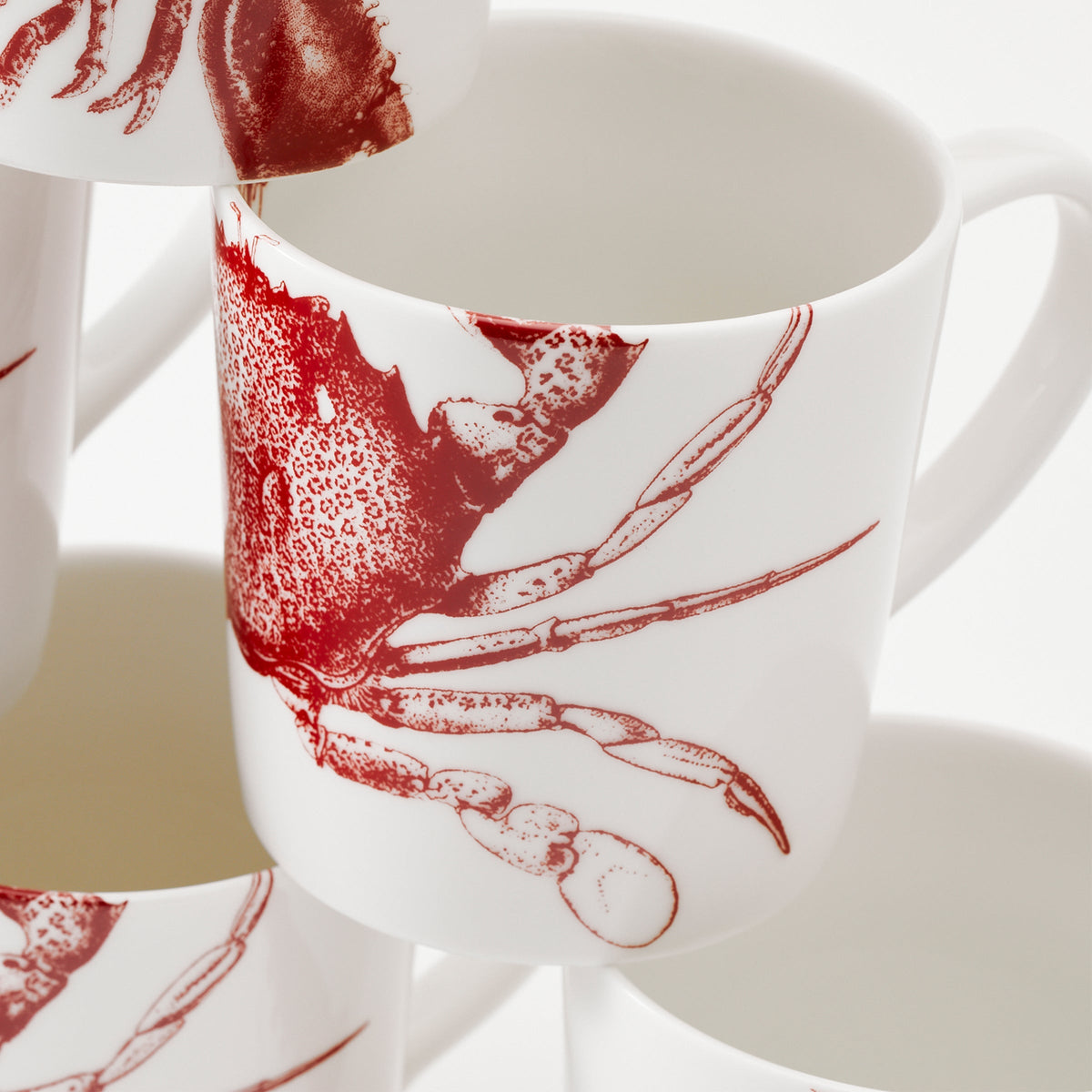Close-up of Crab Red Mug set showcasing red crab patterns on white porcelain mugs with a bright background