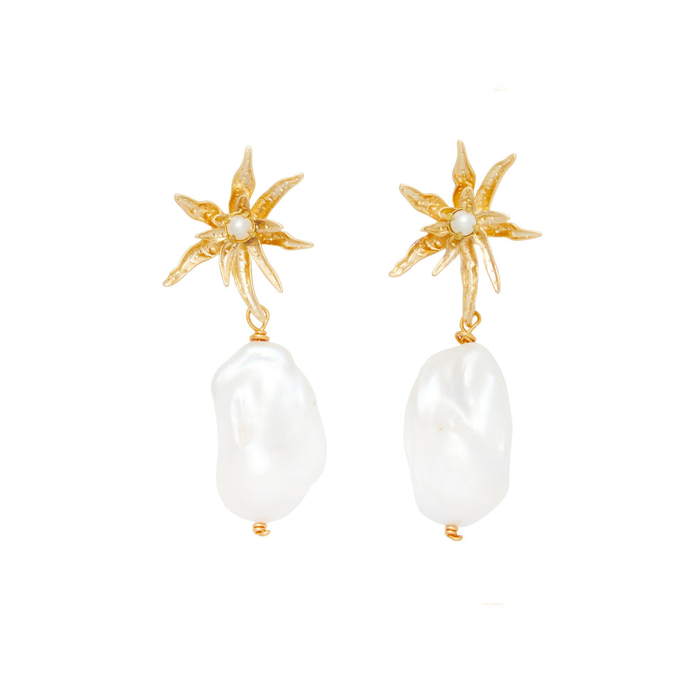 Front of Rehearsal Earrings showcasing gold starburst tops and dangling white baroque pearls on white background