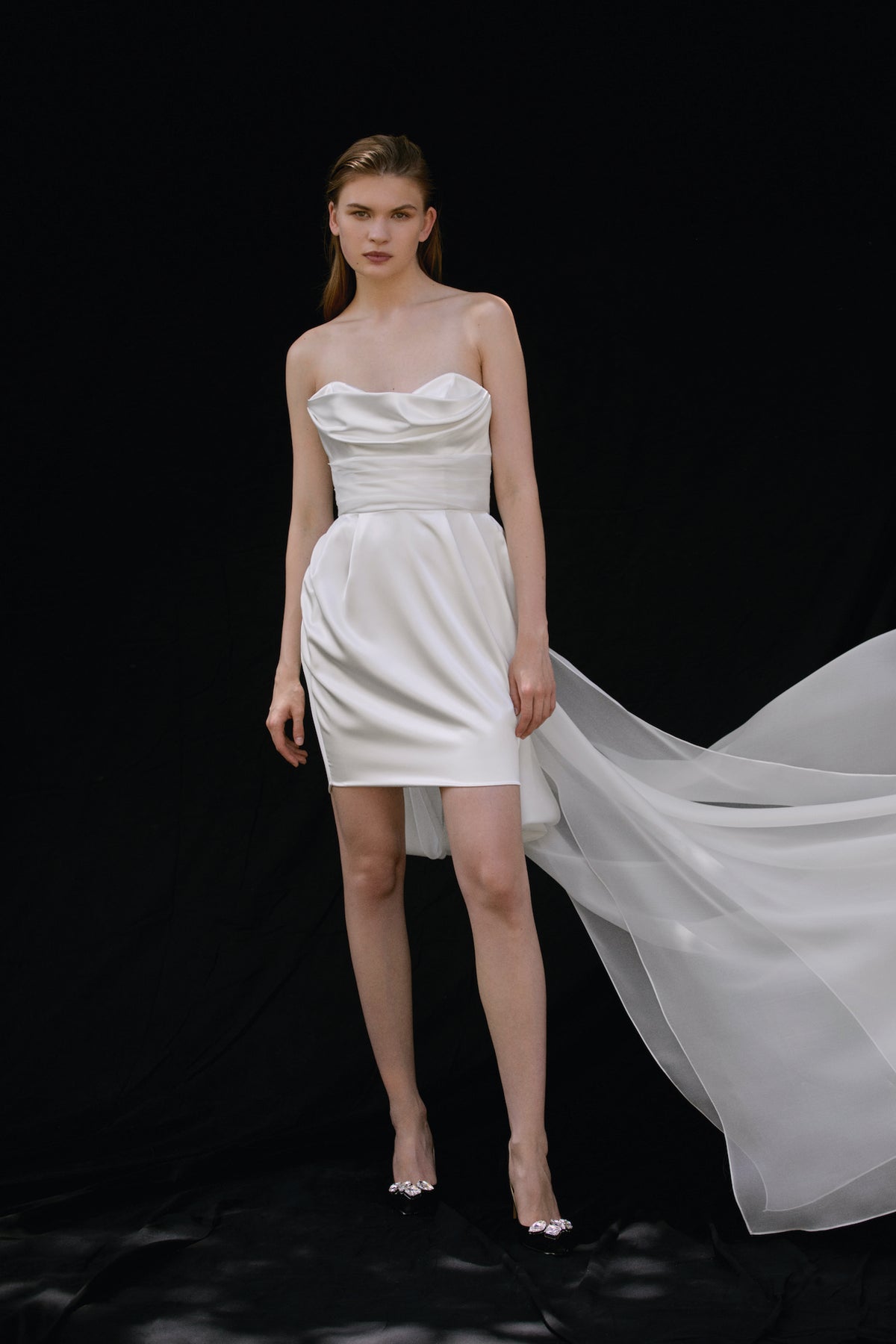 Front view of Rosé Dress showing strapless silk mini with draped waist and flowing organza train on black backdrop