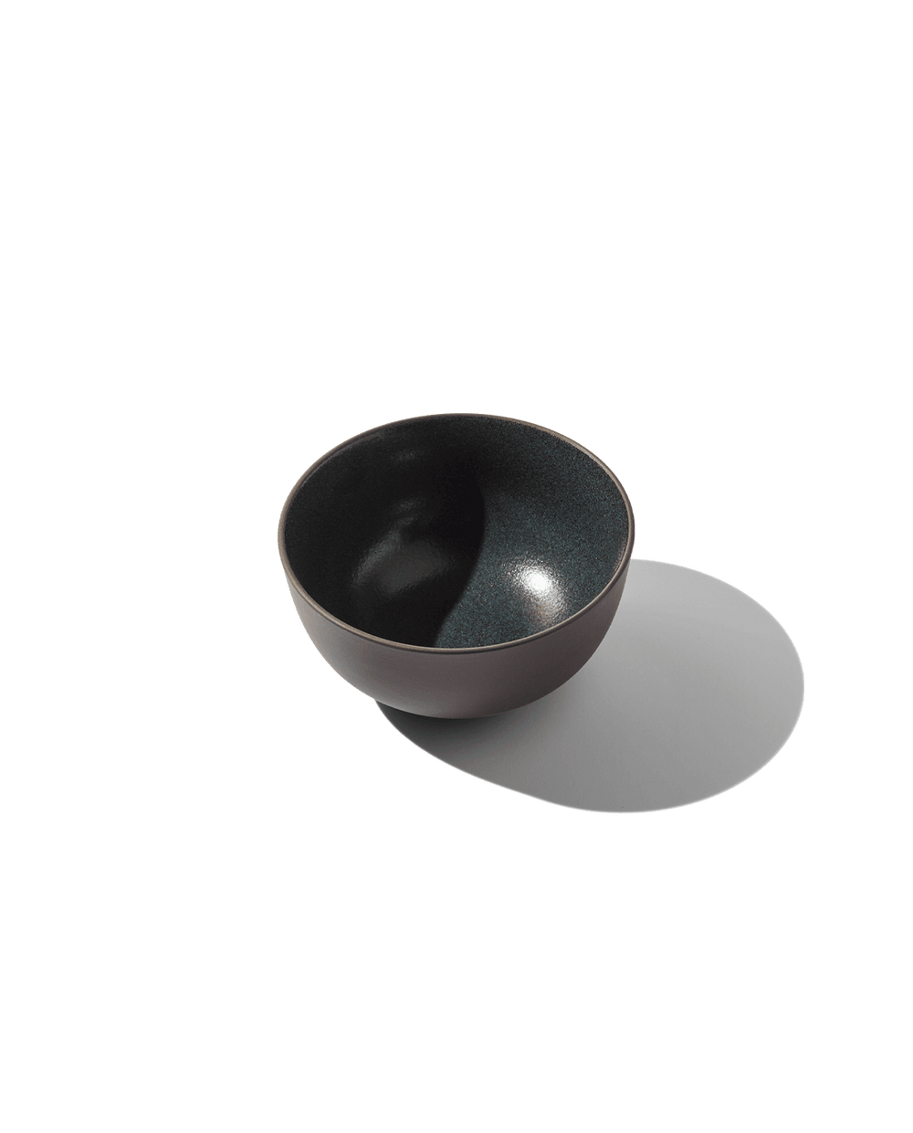 Angled view of Round Bowl showing speckled dark green inner glaze and matte brown exterior on white background