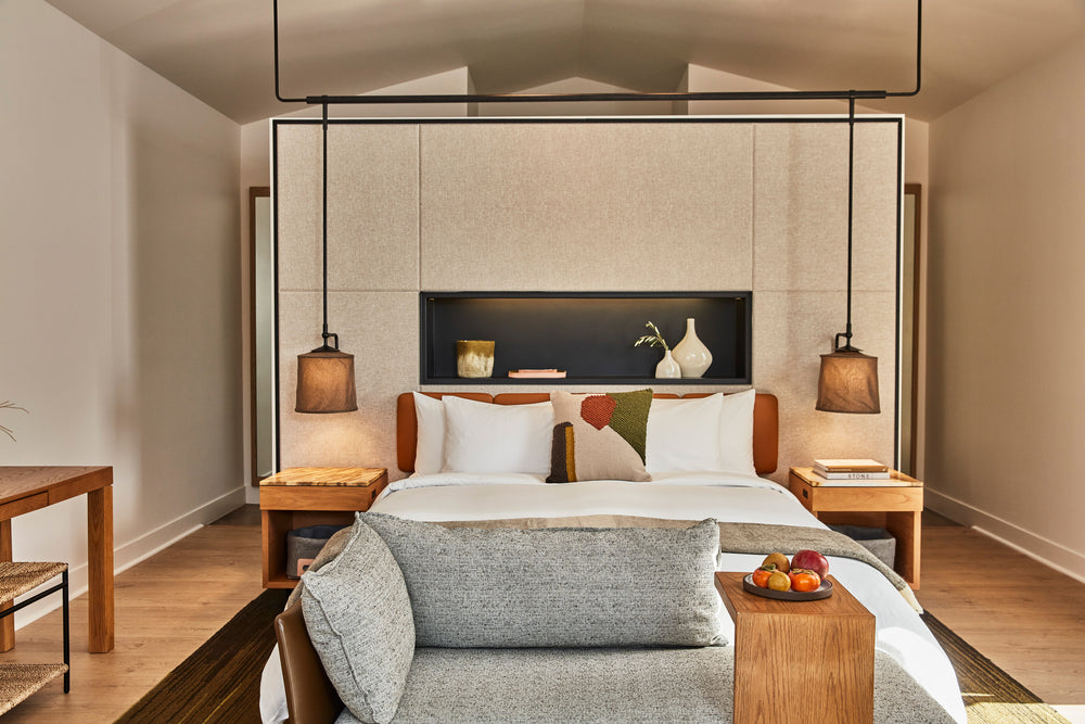 Front view of Calistoga King Studio showing king bed, pendant lamps, sofa bench and wooden side tables in neutral decor