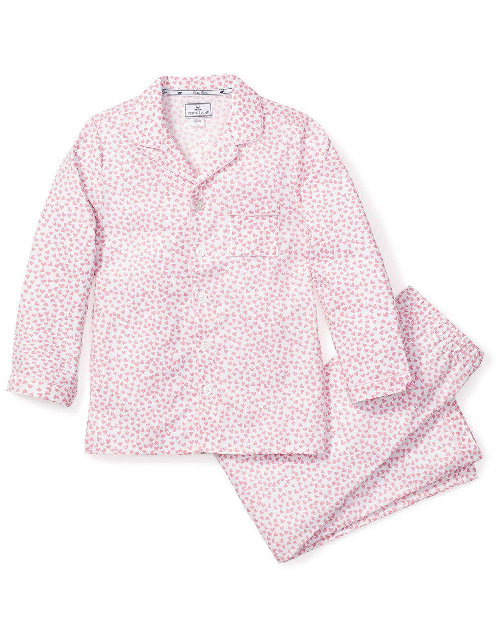 Flat lay of Sweethearts pajama set showing pink heart-patterned button-front top and matching pants on white background