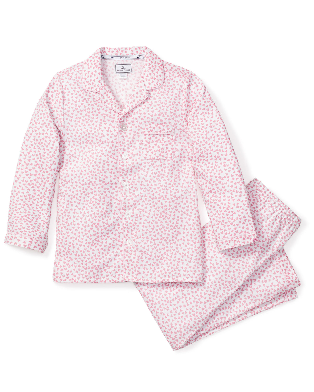 Flat lay of Sweethearts pajama set showing pink heart-patterned button-front top and matching pants on white background
