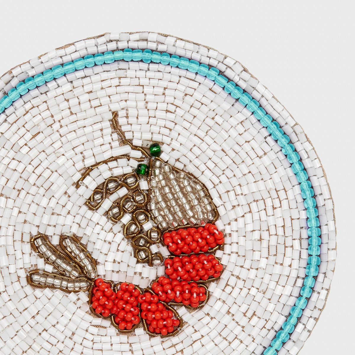Close-up of shrimp coaster showcasing hand-beaded glass beads and red shrimp design on white beaded background