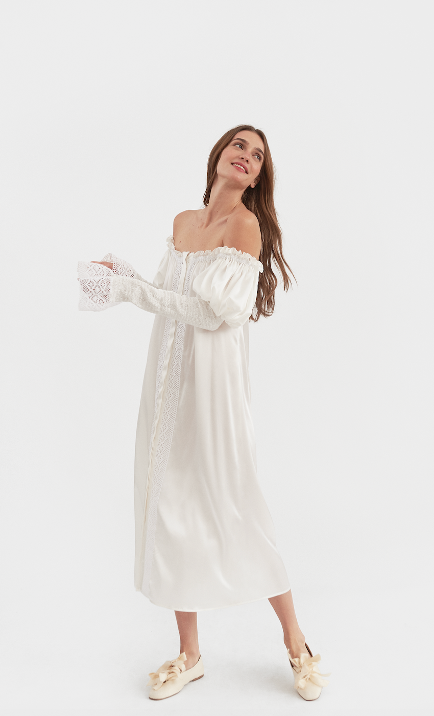Three-quarter view of Opera Silk Dress in Pearl White showcasing its off-shoulder neckline and lace trim on a model