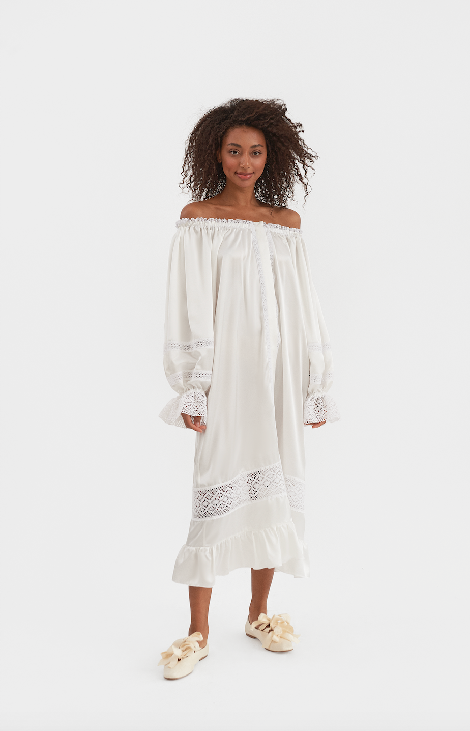 Front view of Paloma Silk Dress in Pearl White showcasing an off-shoulder neckline, lace trim, and ruffled hem on a model
