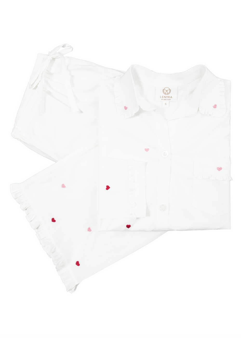 Flat lay of Josie Hearts pajama set showing white top with ruffle collar, pink and red embroidered hearts, and shorts