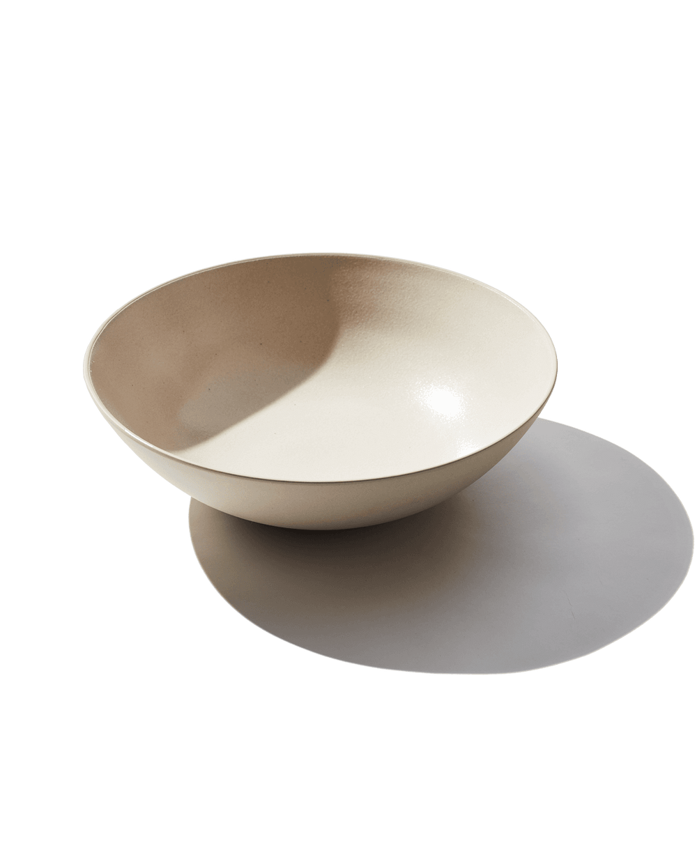 Angled view of Serving Bowl in Dune showing wide shallow shape and matte clay finish on white background