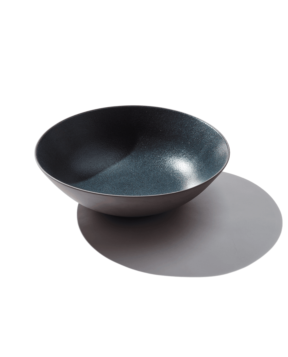 Angled top view of Serving Bowl in Grotto showing speckled blue glazed interior and matte exterior on white background
