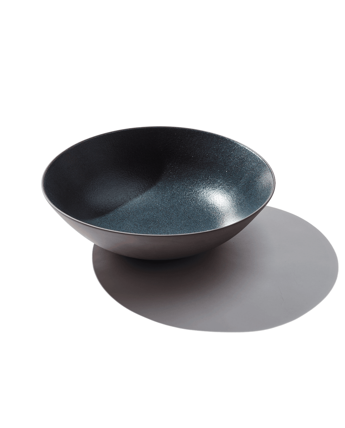 Angled top view of Serving Bowl in Grotto showing speckled blue glazed interior and matte exterior on white background