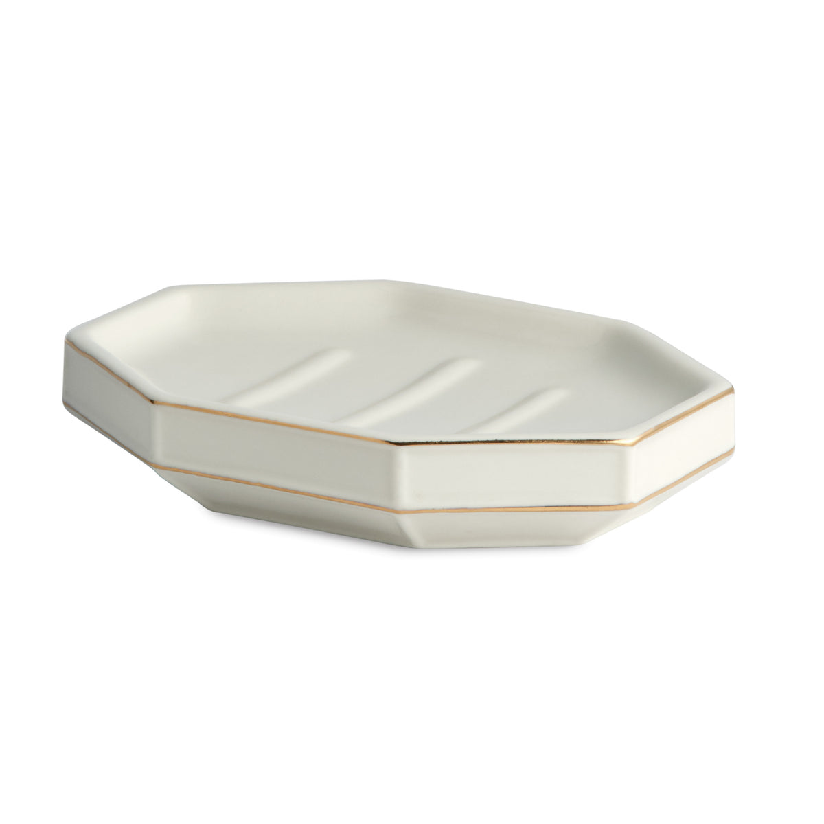 Angled view of St. Honore soap dish with hexagonal porcelain form, gold rim accents and three drainage grooves on white