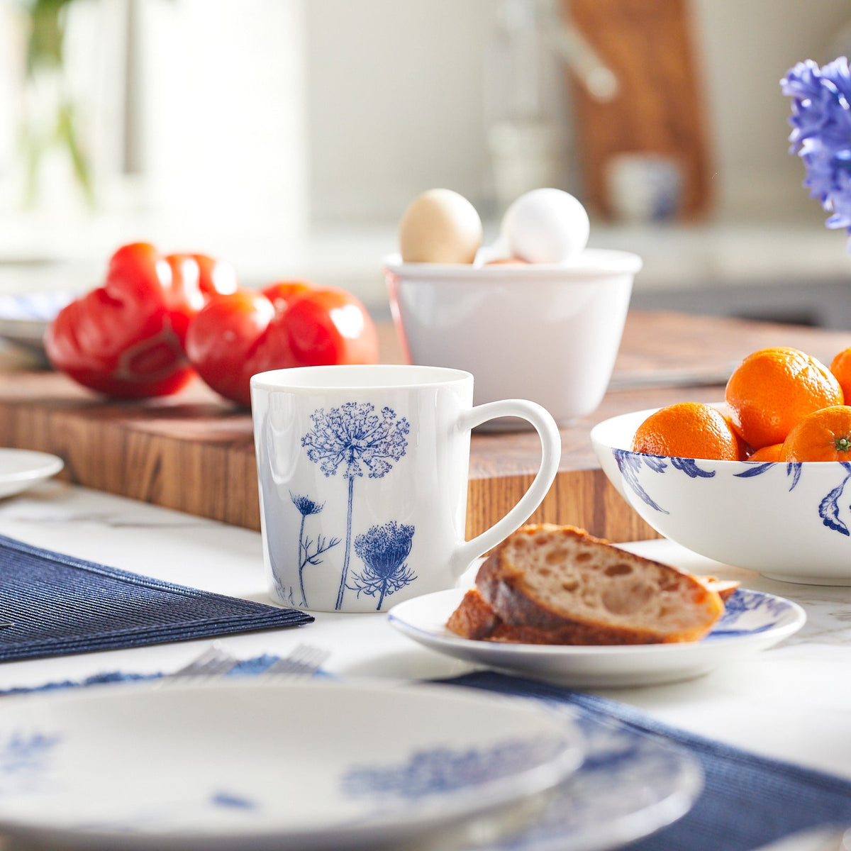 Summer Blues mug on a breakfast table with fruit, bread, and blue floral dishware