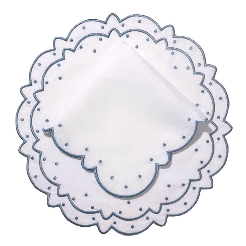 Top view of blue Suzette linen placemat and napkin set showcasing scalloped edges and blue dot embroidery on a white background