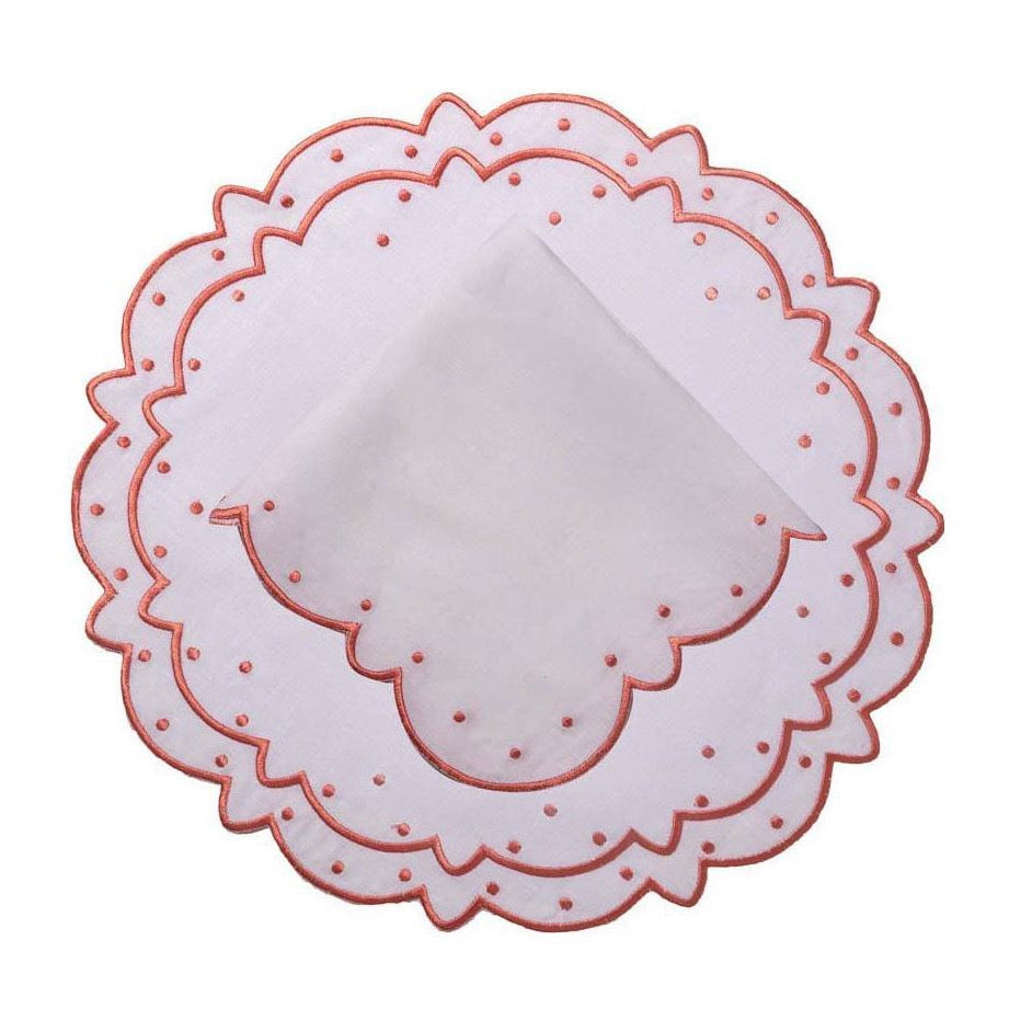 Top view of Suzette linen placemat and napkin set in pink showcasing scalloped edges and dotted embroidery on white