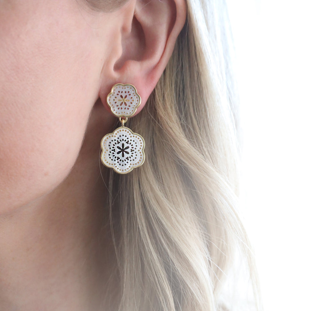 Close up of Tamarin Drop Small earring showing white mother of pearl floral drops and gold vermeil trim worn on ear