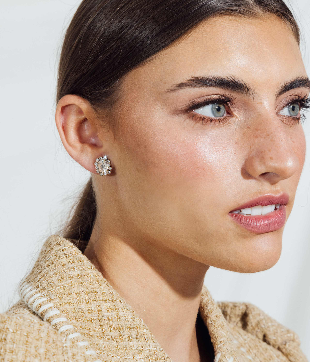 Close-up of Tati Studs in Crystal showcasing hand-set crystals and 18K antiqued gold finish on a model’s ear