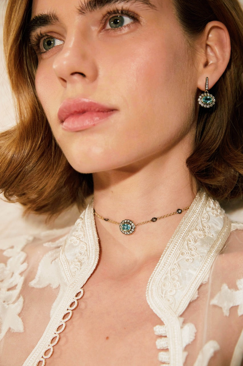 Close-up of Lexie Choker on model showcasing aquamarine center stone surrounded by a diamond halo on a 10K yellow gold chain