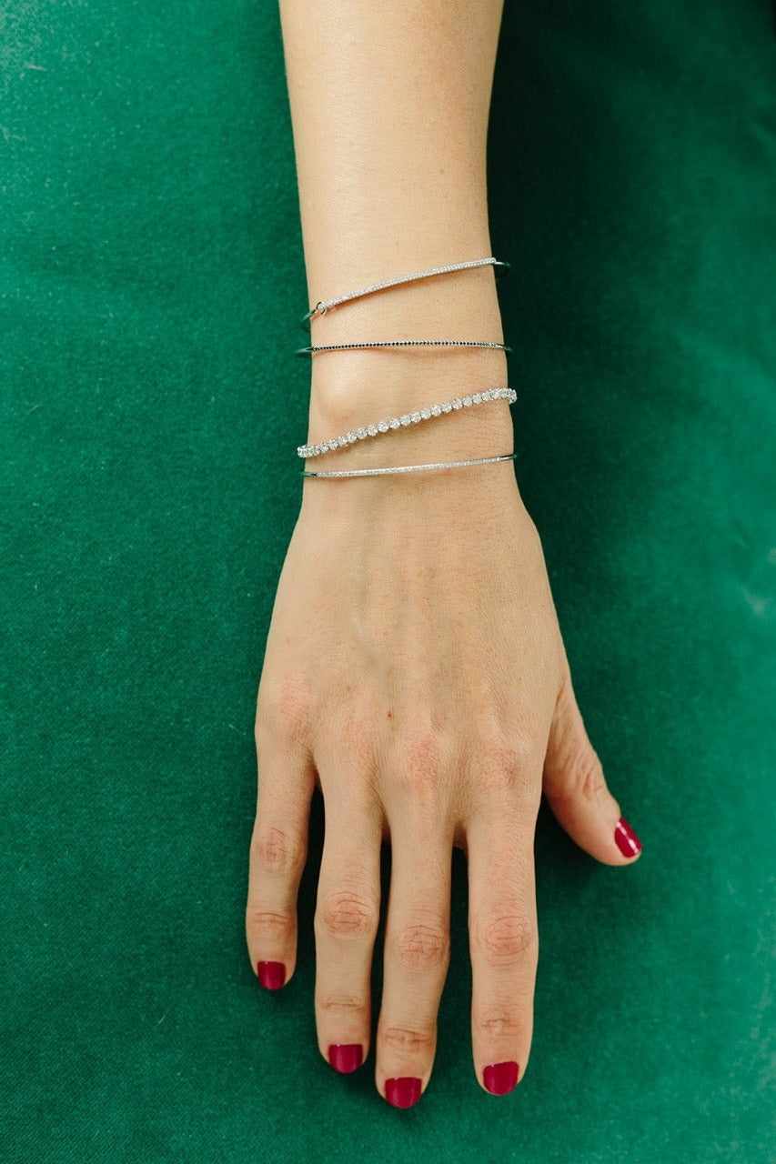 Top view of Gabriela Artigas Tennis Bracelet showcasing brilliant round diamonds on a model’s wrist against a green background