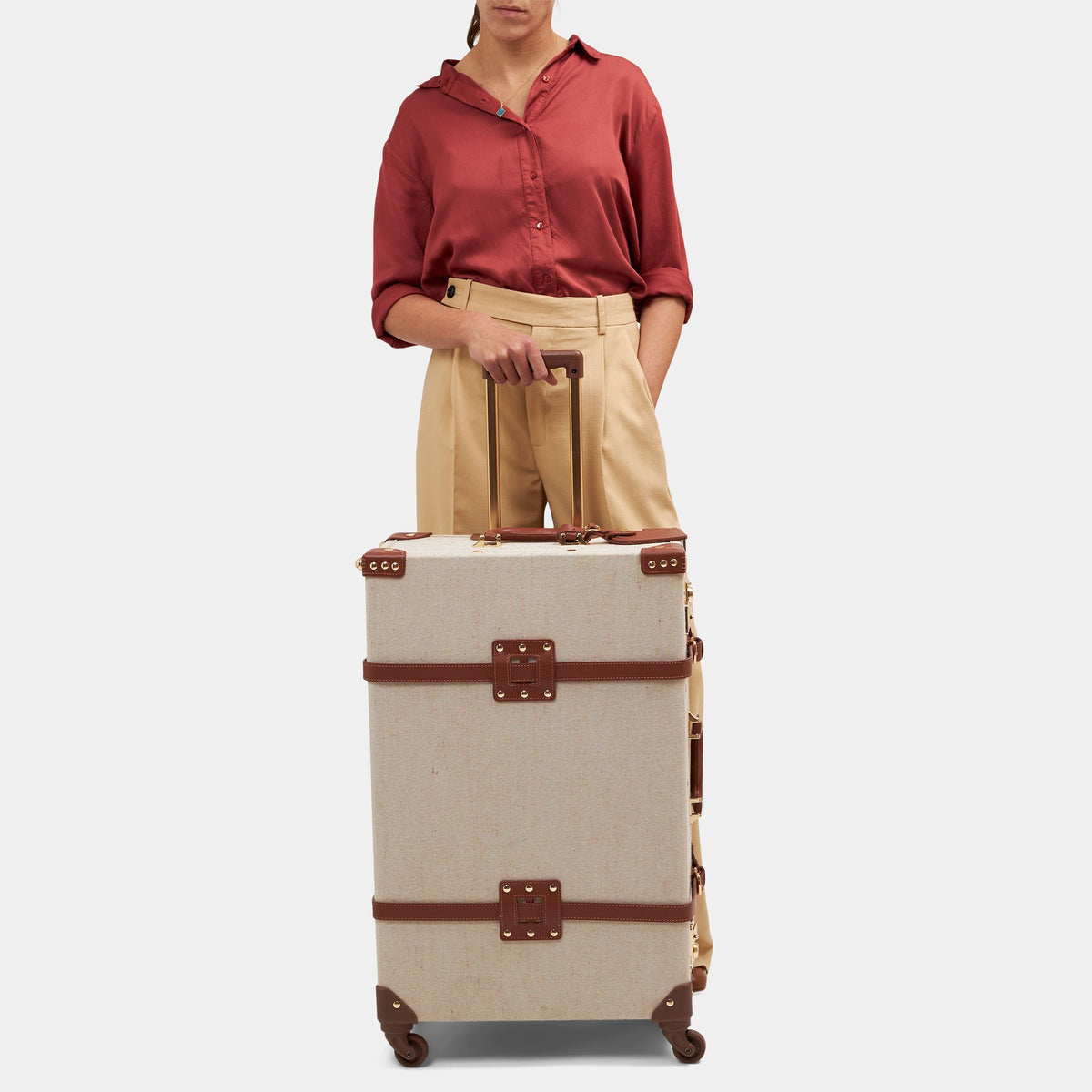 Front view of The Editor Check In Spinner showcasing brown leather straps with extended trolley handle