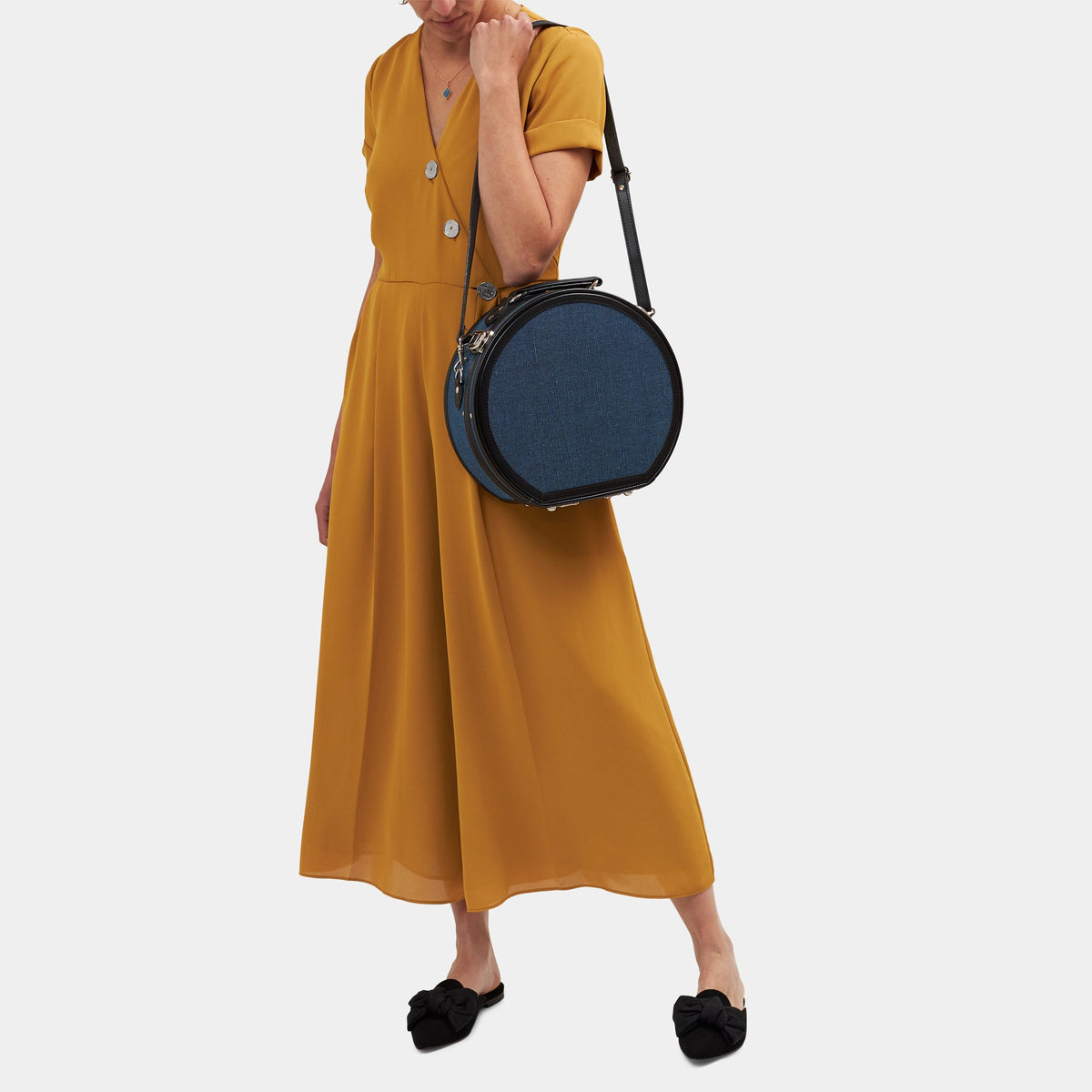 Front view of The Editor in Navy Hatbox Small showcasing black straps and silver latches against a gray background