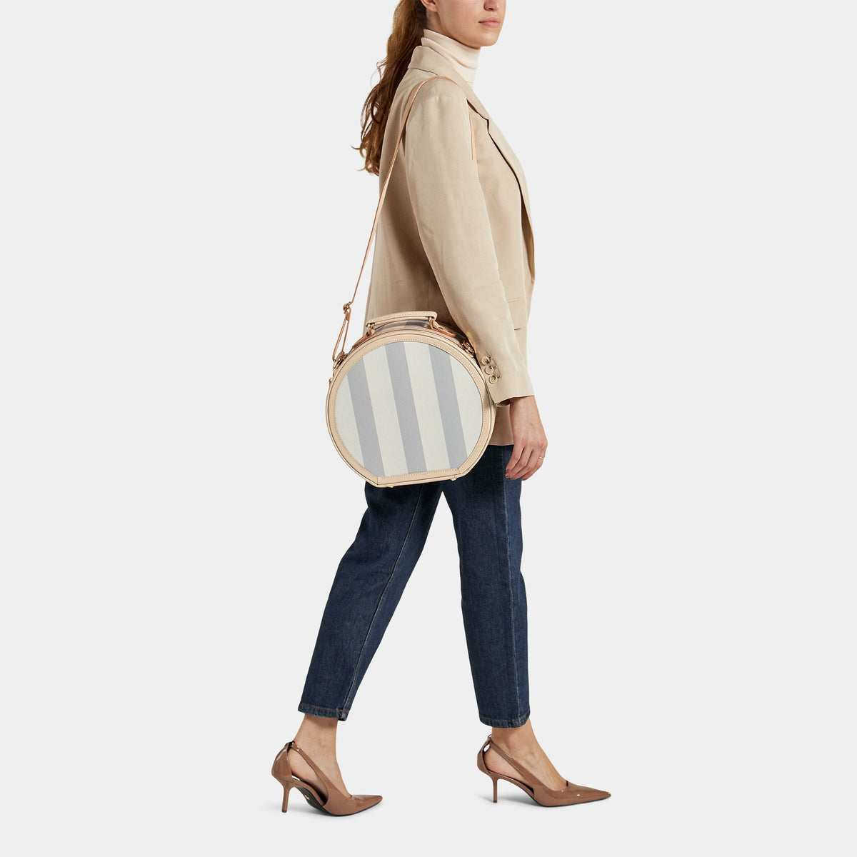 Front view of The Illustrator Small Blue Hatbox showcasing striped blue body and shoulder strap against light gray