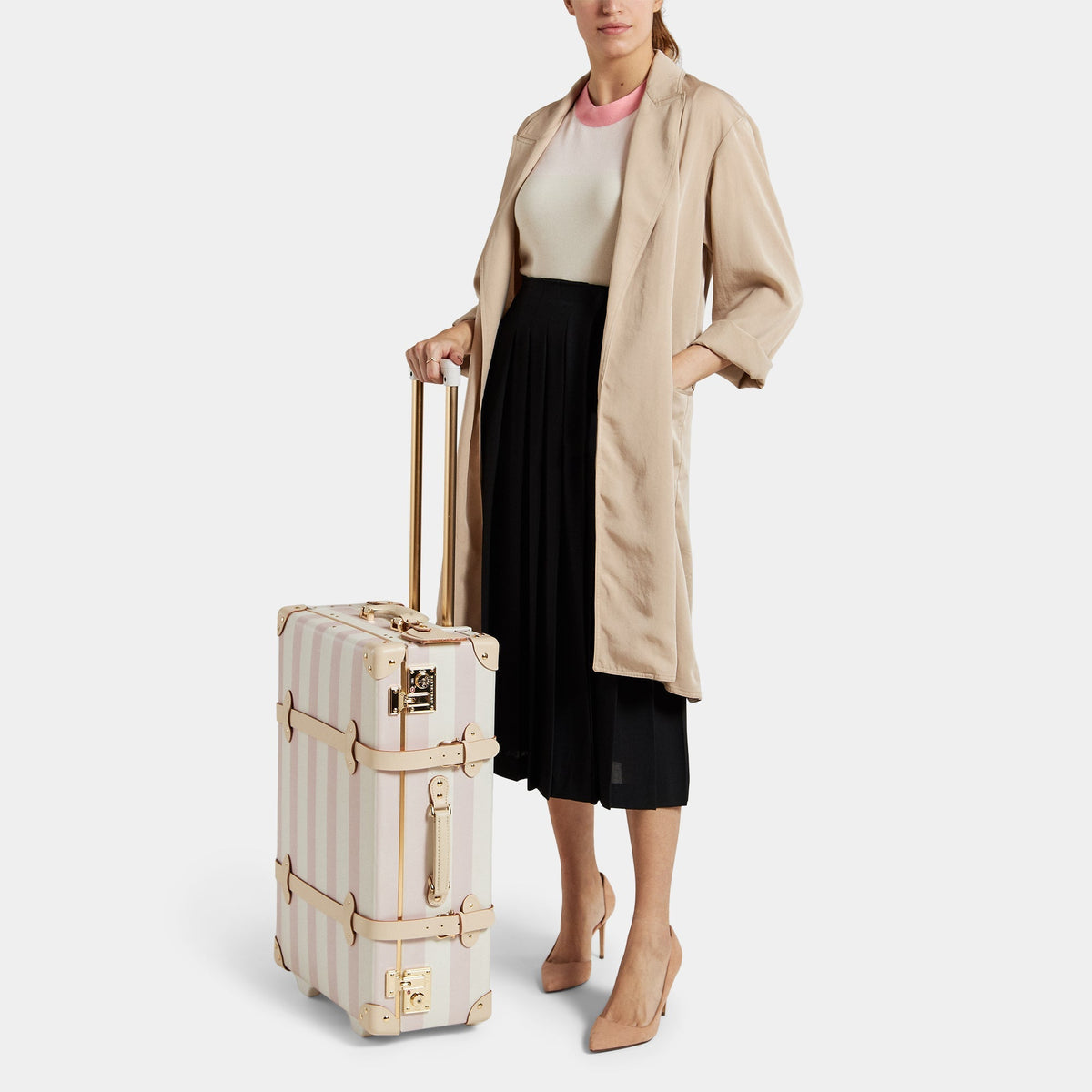 Three-quarter view of The Illustrator Pink Stowaway showcasing striped rose body, tan leather straps, and gold hardware