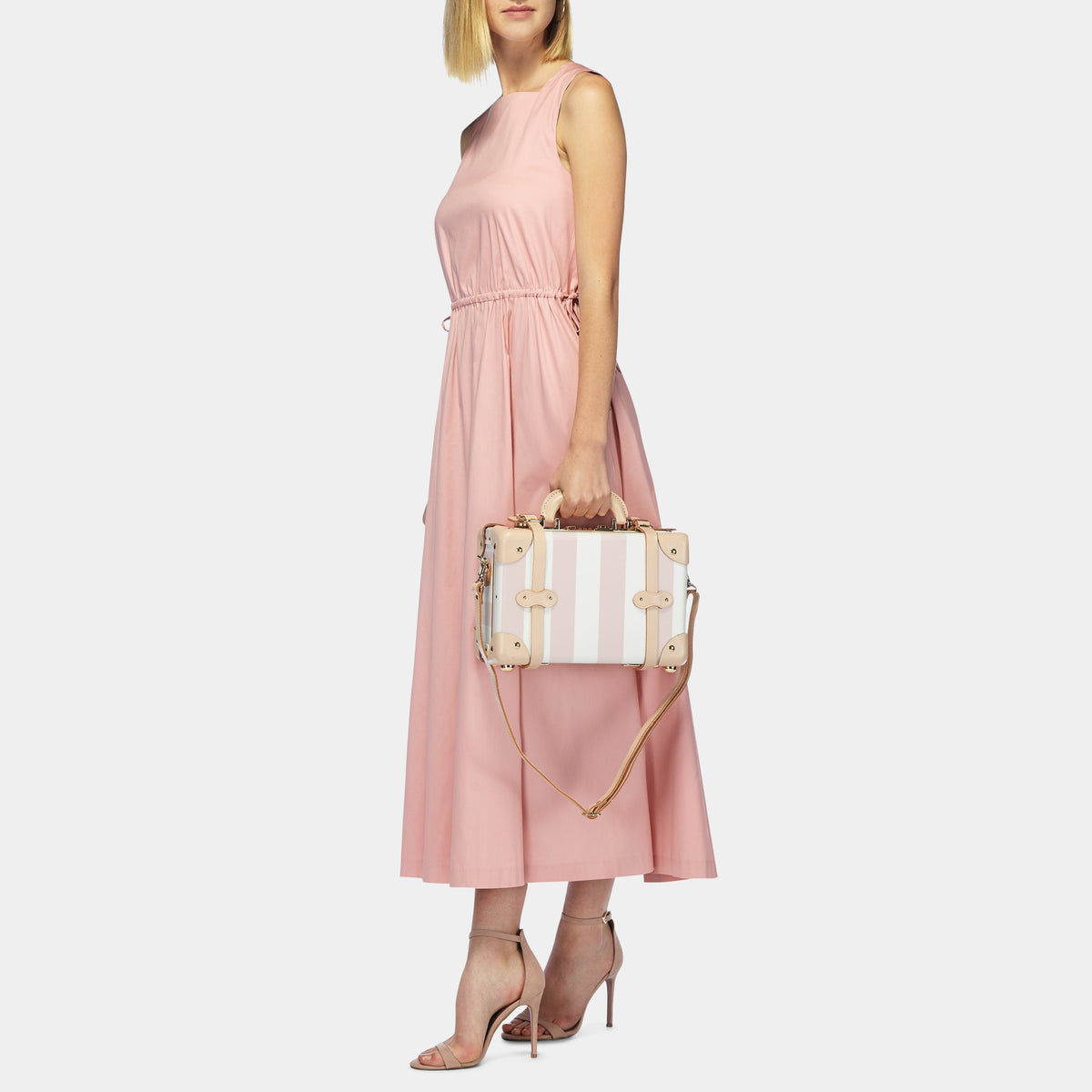 Side view of The Illustrator Pink Vanity showing pink and white stripes, tan trim and gold hardware on gray background