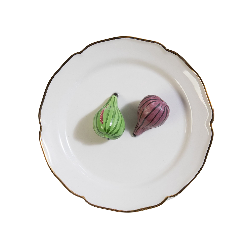 Overhead view of Trompe l’oeil figue decorative plate showcasing two hand-painted figs (green and purple) on a white ceramic plate with a gold rim