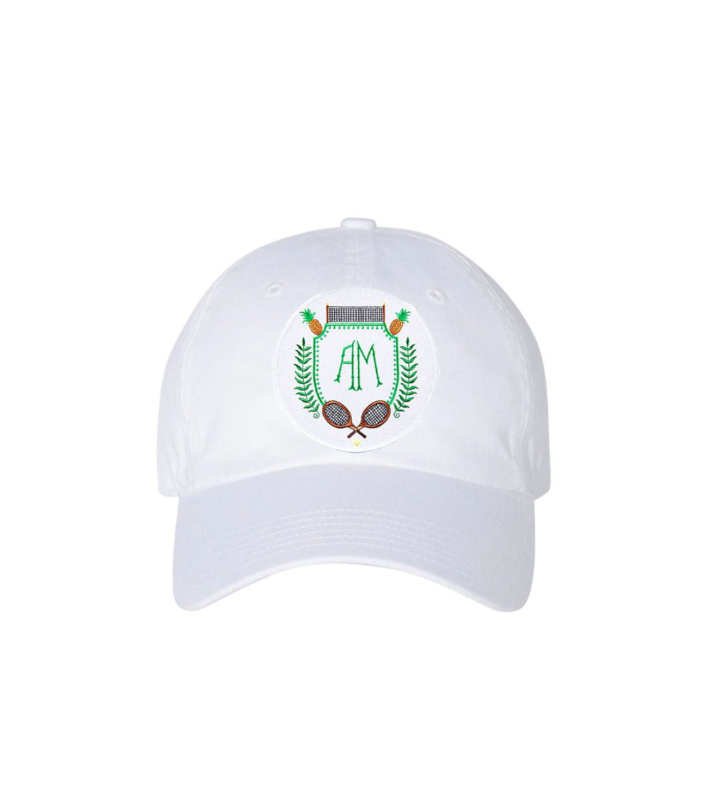 Front view of white patch baseball cap with embroidered crest showing green AM monogram and crossed tennis rackets