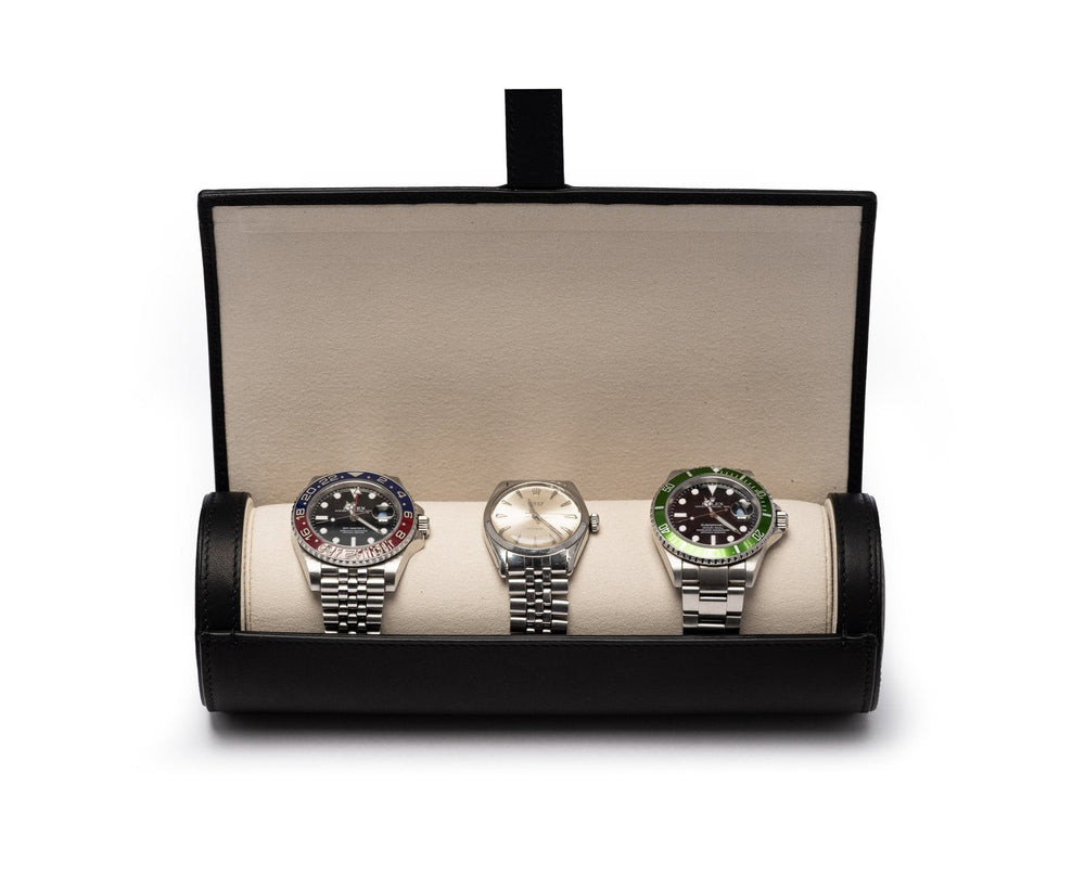 Front view of Watch Roll No. 504 in black leather with suede lining, open to show three watches on a white background