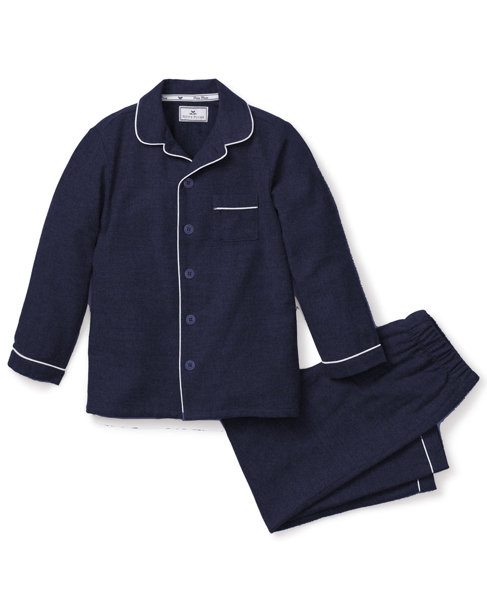 Flat lay of children’s navy flannel pajama set with white piping, button-front top and elastic-waist pants on white