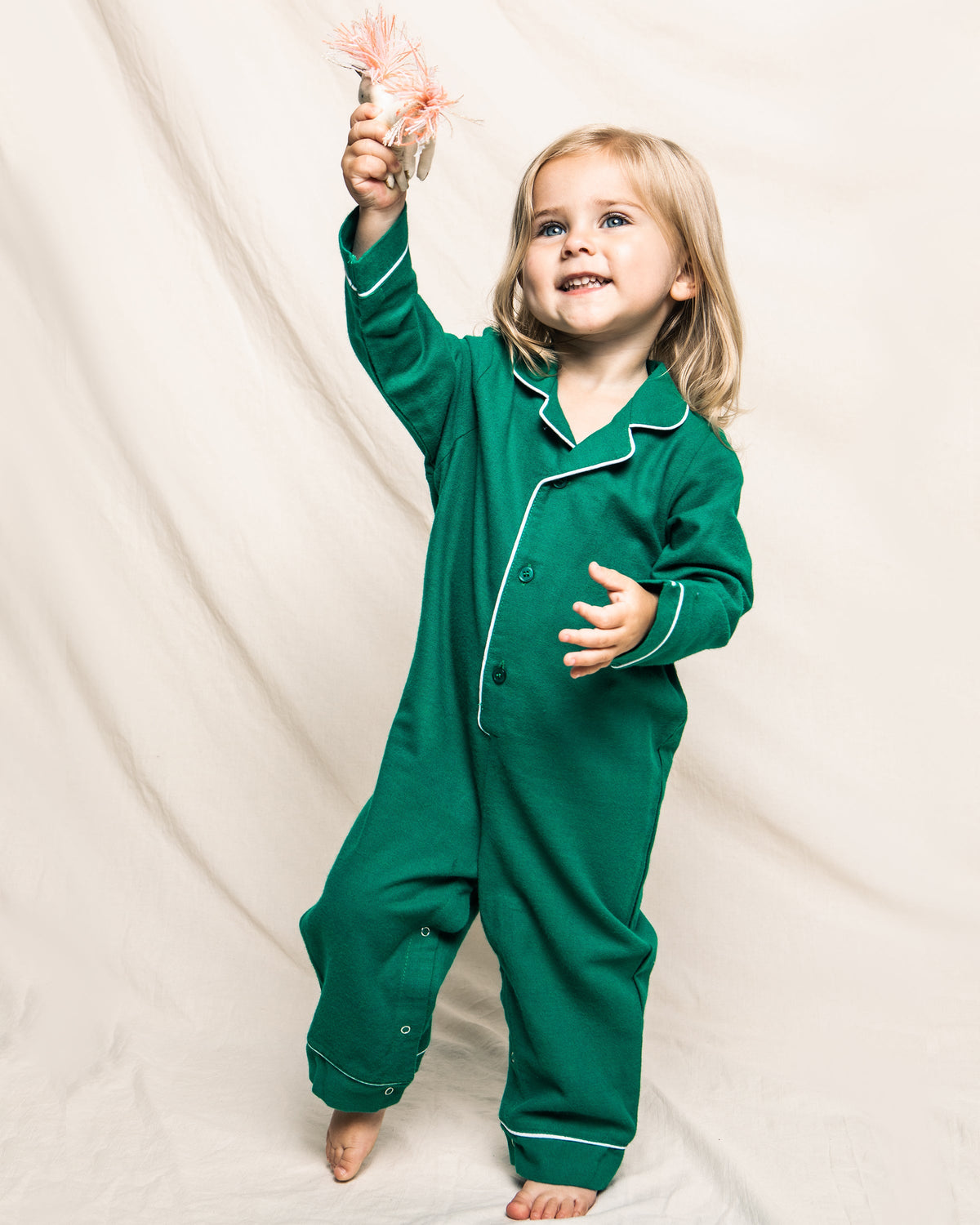 Front view of Forest Green Flannel Romper with White Piping showcasing snap closures on a child against a cream backdrop