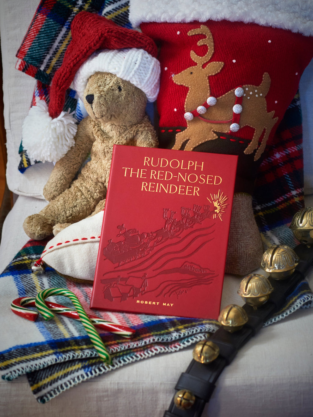 Front view of Rudolph the Red-Nosed Reindeer book showcasing red leather cover and gold embossing with festive items