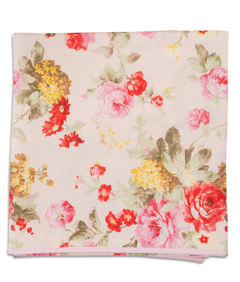 Folded Wild Roses tablecloth showing large watercolor pink and red rose floral print on a light pink background