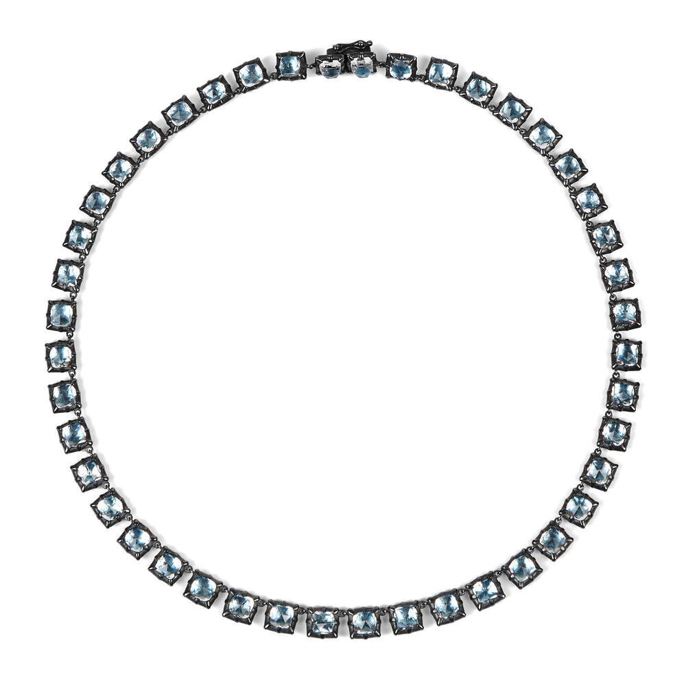 Top-down view of Bella Small Riviere necklace showcasing sky-blue cushion-cut stones in oxidized settings on white background