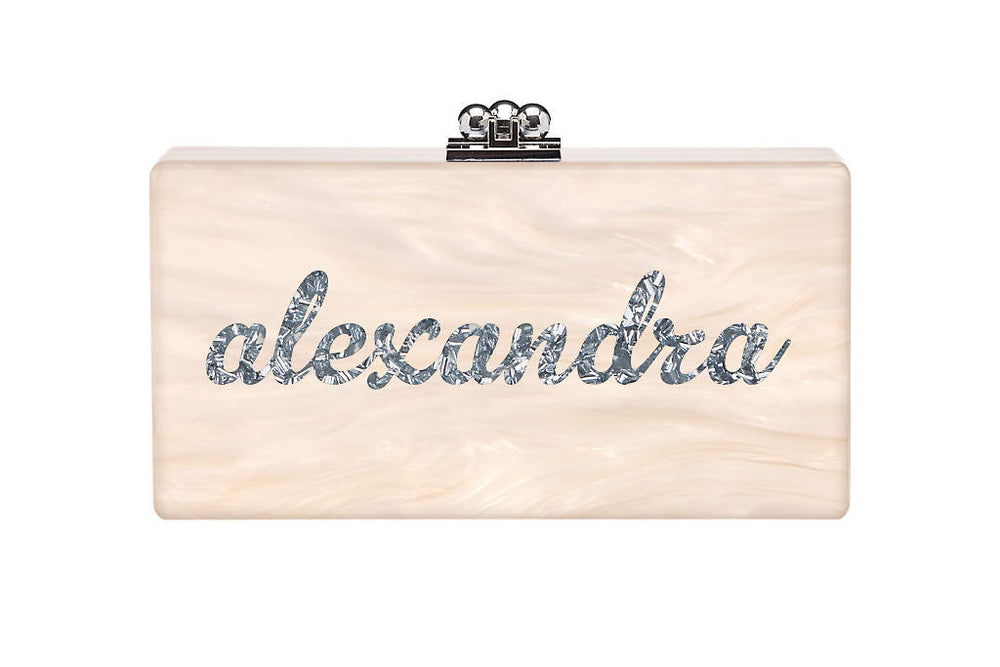 Front view of Custom Slim Jean Clutch showing pearlescent nude acrylic with silver confetti cursive alexandra on white background