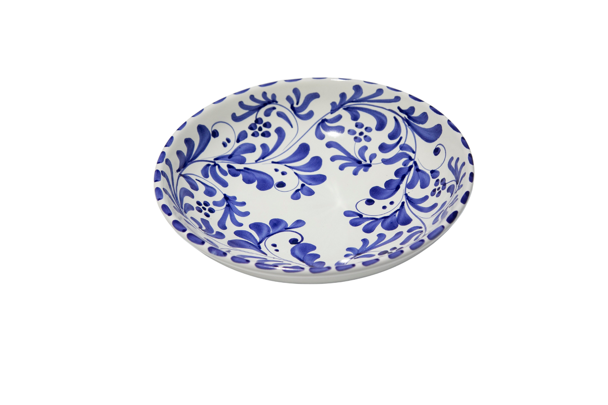 Angled view of Deep Pasta Plate in Azul Classico showcasing swirling leafy impressions with a black background