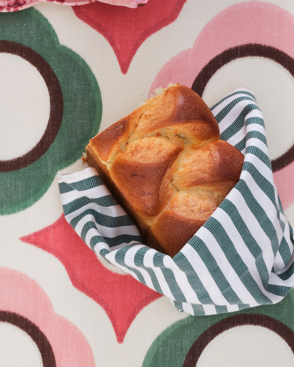 Close-up of Vera Stripe Napkins in Green, Set of 2 showcasing green and white stripes with bread on a table