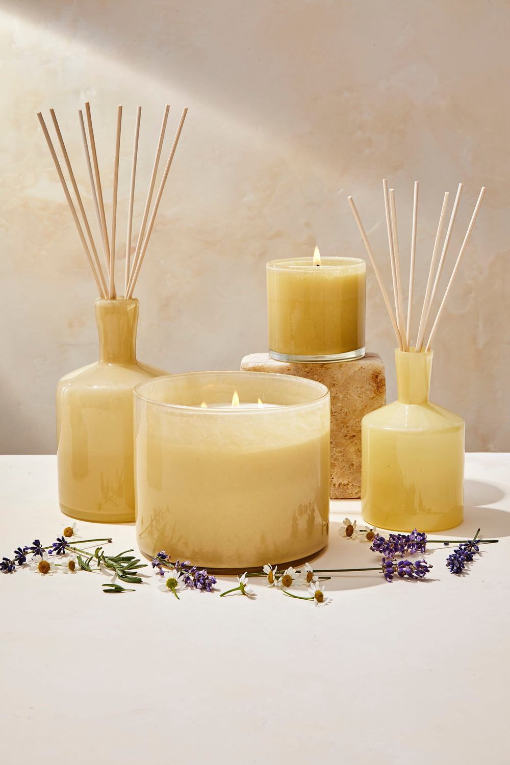 Front view of Chamomile Lavender 3-wick candle in frosted yellow glass with reed diffusers and chamomile and lavender sprigs