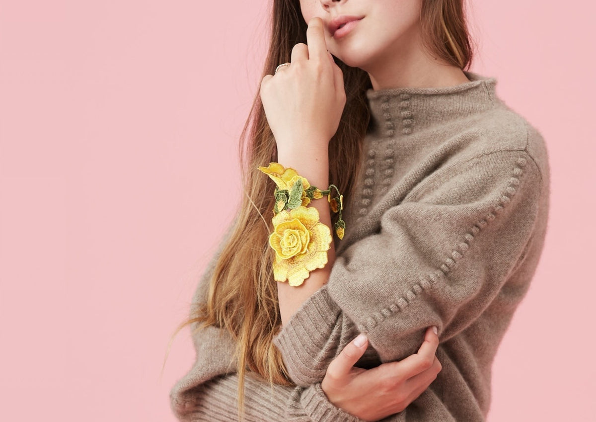 Close-up of The Chelsea sweater in taupe on model showing bobble-stitch trim and mock neck against pink background