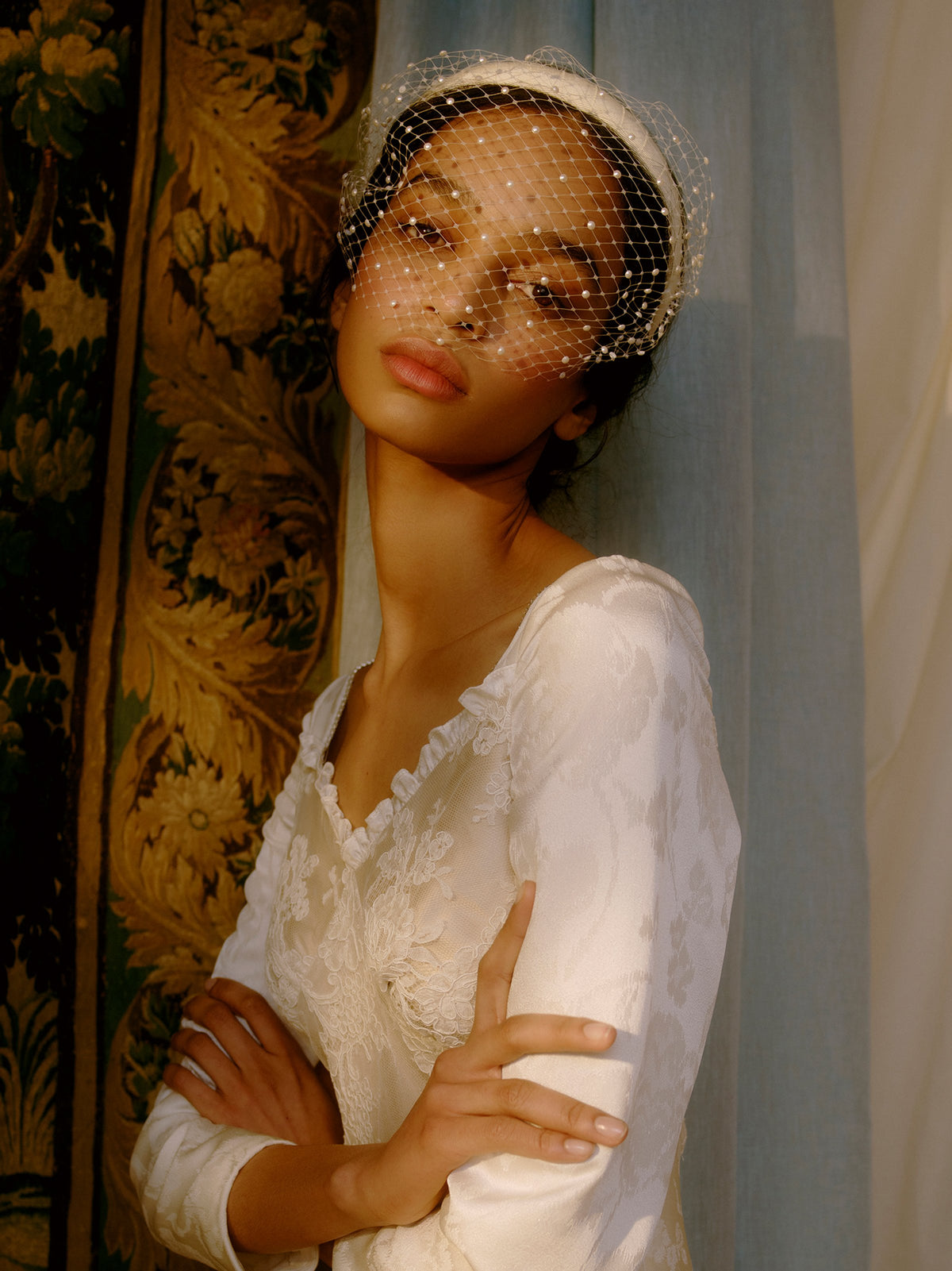 Close-up of Markarian x Gigi Burris Lunella Grosgrain Headband showcasing Swarovski pearl French veiling with floral backdrop