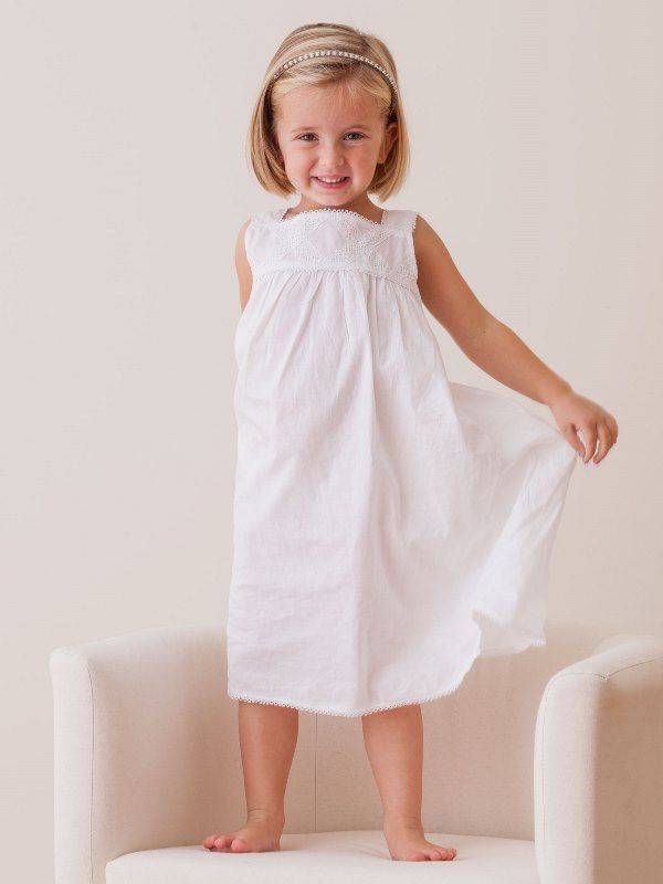 Front view of Chelsea White Cotton Dress for girls on model showcasing strap sleeves, lace trellis bodice and scalloped hem